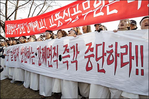 지난 4일 오전 버스를 타고와서 기습적으로 세종로 정부중앙청사앞 도로의 중앙 분리대를 점거한 상복 차림의 전국경찰청고용직공무원노조 조합원들이 자신들의 요구사항이 적힌 현수막을 펼쳐들고 구호를 외치고 있다. 